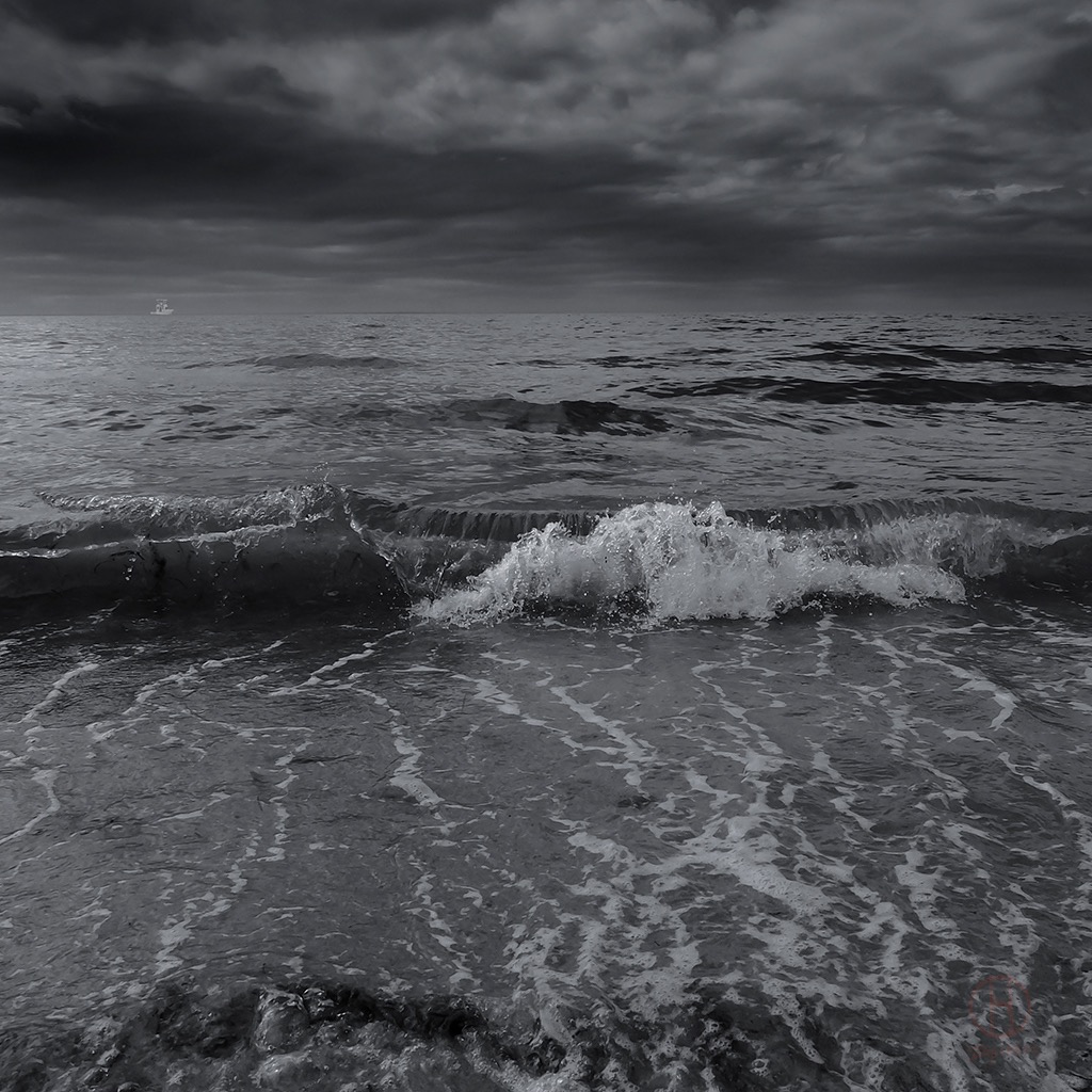 Black and White Ocean Wave. Black and white photograph of wave and fishing boat. Black and White Nature Photograph by Dapixara.